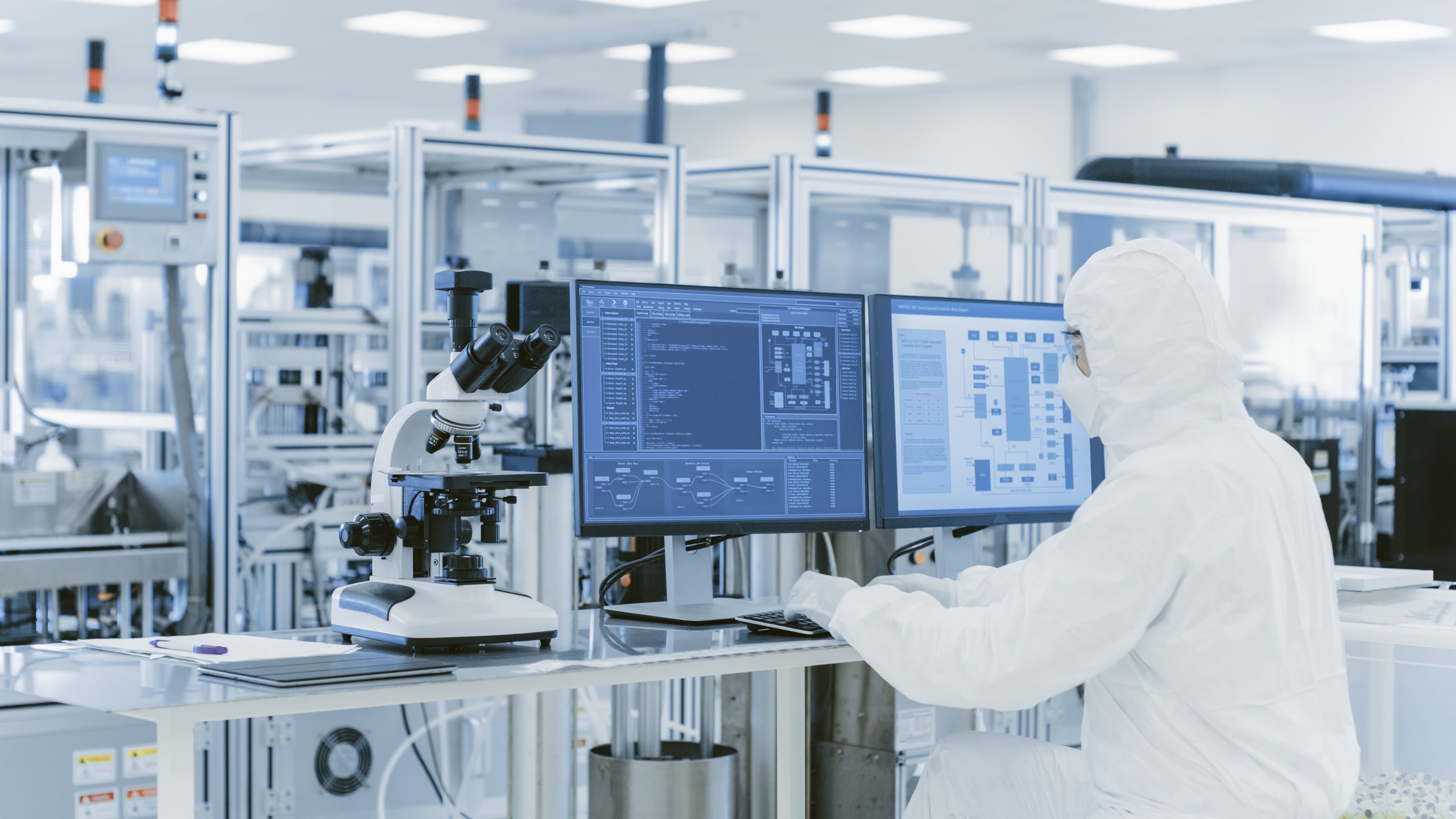 Laboratory worker using a microscope and computer